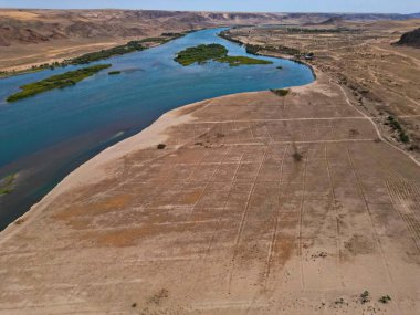 Ili Nehri ve kumlu kıyı bölgesi. Semirechye 'deki en büyük nehir. İnsansız hava aracının görüntüsü. Yılın yaz zamanı..