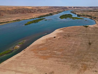 Ili Nehri ve kumlu kıyı bölgesi. Semirechye 'deki en büyük nehir. İnsansız hava aracının görüntüsü. Yılın yaz zamanı..