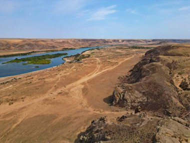 Ili Nehri ve kumlu kıyı bölgesi. Semirechye 'deki en büyük nehir. İnsansız hava aracının görüntüsü. Yılın yaz zamanı..