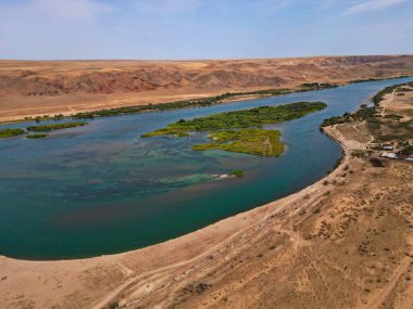 Ili Nehri ve kumlu kıyı bölgesi. Semirechye 'deki en büyük nehir. İnsansız hava aracının görüntüsü. Yılın yaz zamanı..