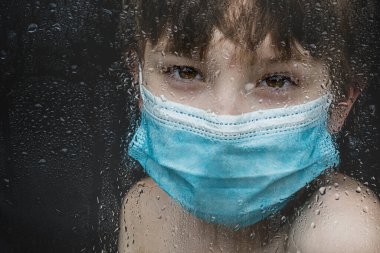 Camdan bakan maskeli çocuk için Covid 19 pandemik geçiş ücreti