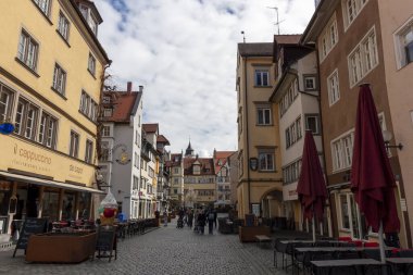 LINDAU, GERMANY - 2 Nisan 2023: Almanya 'da Bodensee Gölü' ndeki Bavyera şehri Lindau 'da rahat bir cadde. Kafesi olan geleneksel yaşlı Alman evleri..