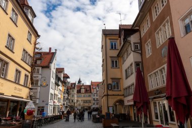 LINDAU, GERMANY - 2 Nisan 2023: Almanya 'da Bodensee Gölü' ndeki Bavyera şehri Lindau 'da rahat bir cadde. Kafesi olan geleneksel yaşlı Alman evleri..