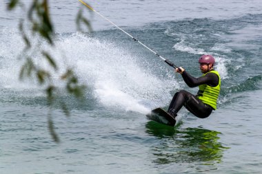 ROMANSHORN, SWitzERLAND - 4 Haziran 2023: bir kılavuz mekanizması ile Wakeboard. Bilinmeyen bir sporcu kabloyu tutar ve seyahat yönünde numaralar yapar..
