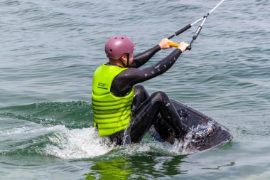 ROMANSHORN, SWitzERLAND - 4 Haziran 2023: bir kılavuz mekanizması ile Wakeboard. Bilinmeyen bir adam kabloyu tutuyor ve su kayağı yapmaya başlıyor.