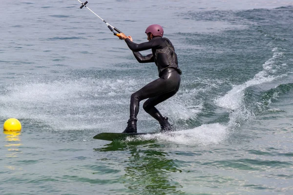 ROMANSHORN, SWitzERLAND - 4 Haziran 2023: bir kılavuz mekanizması ile Wakeboard. Bilinmeyen bir sporcu kabloyu tutar ve seyahat yönünde numaralar yapar..