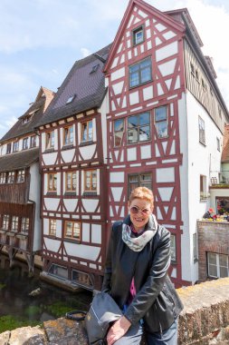 Yarım ahşap bir evin önünde güneş gözlüklü çekici olgun bir kadın, Ulm.