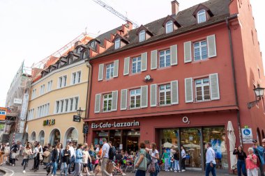 FREIBURG, ALMANY - 6 Mayıs 2023: Yoldan geçenlerin şehrin tarihi merkezinde cadde boyunca yürüdükleri görüntü