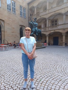 Almanya 'nın Stuttgart kentindeki eski şatoyu gezerken güzel, olgun bir kadın. Yaz zamanı.