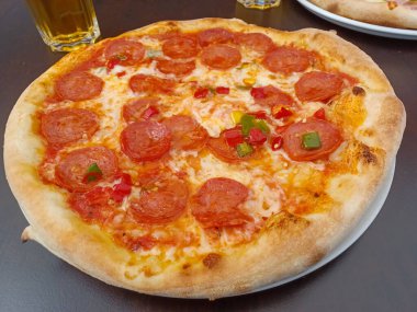 Gri taşlı arka planda salamlı pepperonili pizza. Yakın çekim, seçici odaklanma