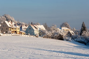 Avrupa 'nın bir köyünde güzel bir kış. Kır evlerinin arka planında karla kaplı bir tarlanın manzarası. Almanya