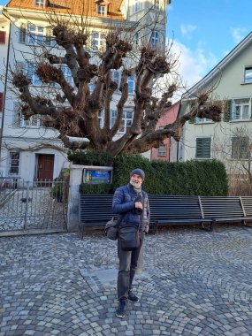 St. Gallen meydanındaki olgun bir kadının uzun bir görüntüsü. Ocak güneşli gün