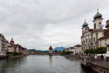 LUCERNE, SWitzERLAND - 13 Temmuz 2024: Lucerne 'deki Cizvitenkirche yakınlarındaki Reuss nehrinin setinde her zaman birçok turist vardır.