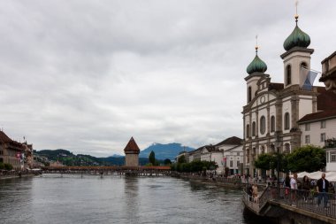 LUCERNE, SWitzERLAND - 13 Temmuz 2024: Lucerne 'deki Cizvitenkirche yakınlarındaki Reuss nehrinin setinde her zaman birçok turist vardır.