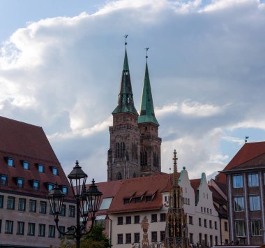 NUREMBERG, GERMANY - 19 Mayıs 2024: St. Lorenz Katedrali ve Schoener Brunnen 'in Nuremberg, Bavyera' daki arka planına karşı sokak ışıkları