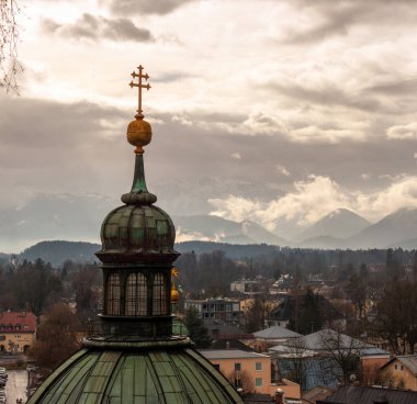 Salzburg 'daki St. Erhard Kilisesi karlı havada dağların arkasına karşı. Salzburg