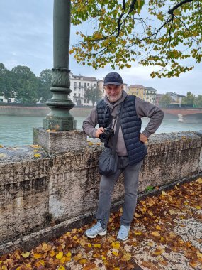 Kameralı olgun bir adam Verona 'nın sonbahar seti üzerinde duruyor.