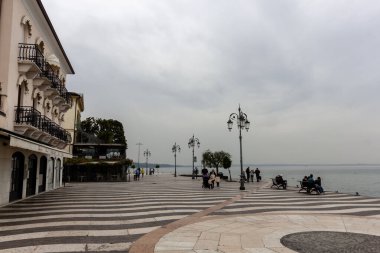 Lazis, İtalya - 25 Ekim 2024: Bulutlu bir Ekim gününde Lazise 'in rıhtımı. Garda Gölü