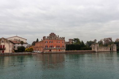 Lazise 'in tekneden manzarası ortaçağ duvarlarını ve kasabanın mimarisini aydınlatıyor. Ekim