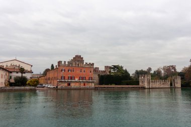 Lazise 'in tekneden manzarası ortaçağ duvarlarını ve kasabanın mimarisini aydınlatıyor. Ekim