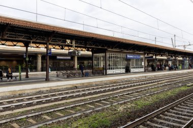 VERONA, ITALY - 22 Ekim 2024: İtalya 'daki Verona Porta Nuova tren istasyonundaki platformlar, raylar, tepe örtüleri ve bekleyen yolcular