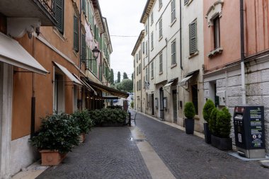 PESCHIERA DEL GARDA, İtalya - 22 Ekim 2024: Peschiera del Garda, İtalya 'da renkli binalarla bir sokak sahnesi