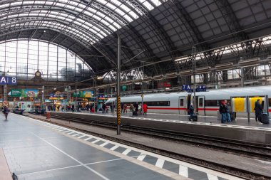 FRANKFURT (MAIN), GERMANY - 4 Aralık 2024: Frankfurt Hauptbahnhof (Frankfurt Merkez İstasyonu), Almanya, platformunda bir tren ve bekleyen insanlar. Ayırt edici cam ve çelik çatı görünür.