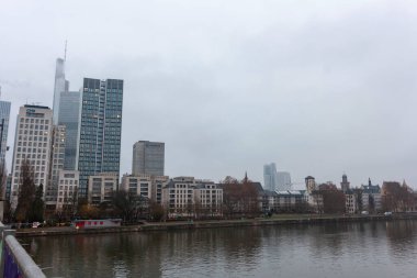 FRANKFURT (MAIN), GERMANY - 1 Aralık 2024: Bulutlu bir günde Frankfurt siluetinin Untermainbruecke 'den (Aşağı Ana Köprü) görüntüsü