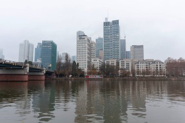 FRANKFURT (MAIN), GERMANY - 1 Aralık 2024: Frankfurt am Main River ve Bankenviertel 'in gökdelenleri bulutlu bir günde