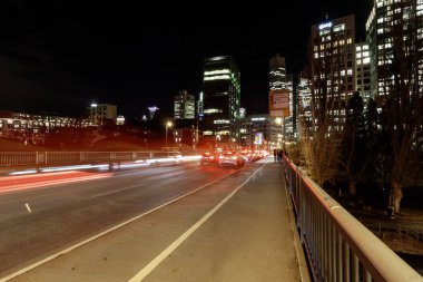 FRANKFURT (MAIN), GERMANY - 3 Aralık 2024: Frankfurt am Main, Almanya 'dan geçen bir köprüden gece görüntüsü, Bankenviertel' in aydınlık gökdelenlerini, tarihi binaları ve trafikten geçen ışık yollarını gösteriyor