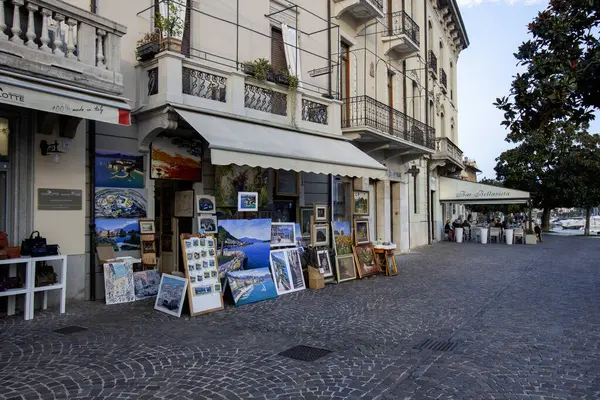 SALO, İTALYA - 22 EKİM 2024: Sanat atölyesi mağazasının önünde sayısız resim ve resim sergiliyor