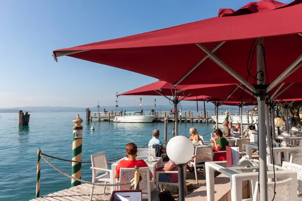 SIRMION, İtalya - 22 Ekim 2024: Sirmione, İtalya 'da Garda Gölü kıyısındaki açık hava kafe