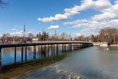 LINDAU, GERMANY - 22 Mart 2025: Lindau Köprüsü (Seebruecke), Lindau, Almanya 'daki Constance Gölü' nün (Bodensee) sakin ve mavi suları üzerinde uzanan modern köprü