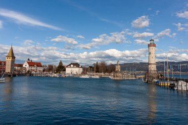 LINDAU, GERMANY - 22 Mart 2025: Bu geniş açılı çekim, Almanya 'da Constance Gölü' nde (Bodensee) sevimli bir ada kasabası olan Lindau 'nun limanının girişini yakalar.