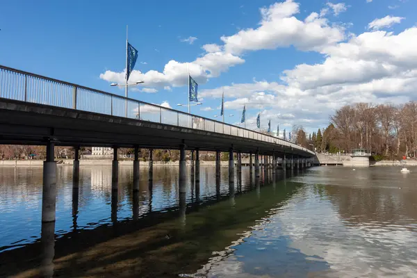 LINDAU, GERMANY - 22 Mart 2025: Lindau Köprüsü (Seebruecke), Lindau, Almanya 'daki Constance Gölü' nün (Bodensee) sakin ve mavi suları üzerinde uzanan modern köprü