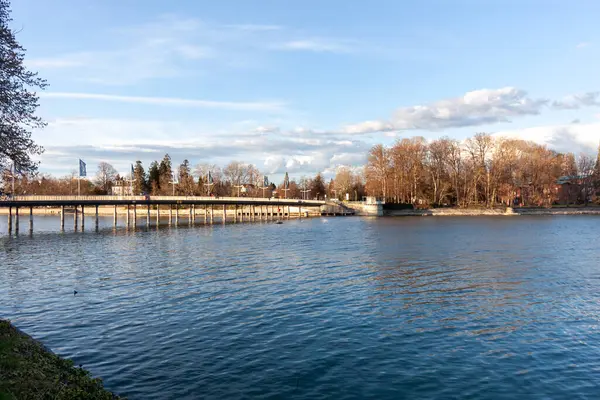 LINDAU, GERMANY - 22 Mart 2025: Lindau Köprüsü (Seebruecke), Lindau, Almanya 'daki Constance Gölü' nün (Bodensee) sakin ve mavi suları üzerinde uzanan modern köprü