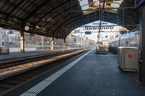St. GALLEN - SWitness ZERLAND - 19 Ocak 2025 St. Gallen tren istasyonu platformu ve büyük, kemerli bir çatı altında park edilmiş bir tren.