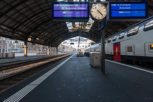 St. GALLEN - SWitness ZERLAND - 19 Ocak 2025 St. Gallen tren istasyonu platformu ve büyük, kemerli bir çatı altında park edilmiş bir tren.