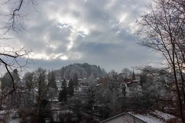 Aziz Gallen 'in panoramik kış manzarası karla kaplı ağaçların ve bulutlu bir gökyüzünün altında yuvarlanan tepelerin arasına yuva yapmış.