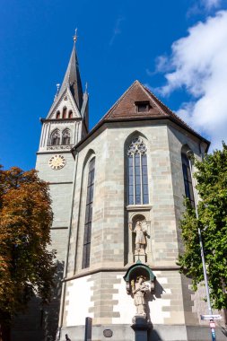 Almanya 'nın Konstanz kentindeki tarihi St. Stephen Kilisesi' nin (Stephanskirche) çarpıcı alçak açılı manzarası, dağınık bulutlarla dolu mavi bir gökyüzüne karşı dimdik ayakta duruyor.