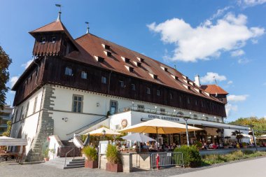 KONSTANZ, GERMANY - 24 Eylül 2023: Konstanz, Almanya 'daki tarihi Konzilgebaude (Konsey Binası), açık, güneşli bir günde parlak mavi bir gökyüzü ve tüylü beyaz bulutlarla görkemli bir şekilde duruyor