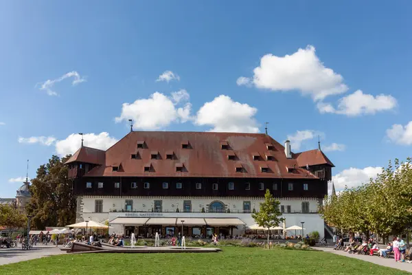 KONSTANZ, GERMANY - 24 Eylül 2023: Konstanz, Almanya 'daki tarihi Konzilgebaude (Konsey Binası), açık, güneşli bir günde parlak mavi bir gökyüzü ve tüylü beyaz bulutlarla görkemli bir şekilde duruyor