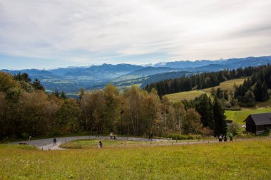 Avusturya 'daki Pfaender dağından nefes kesen panoramik manzara ufuk boyunca uzanan görkemli kar örtülü Alpleri gösteriyor.