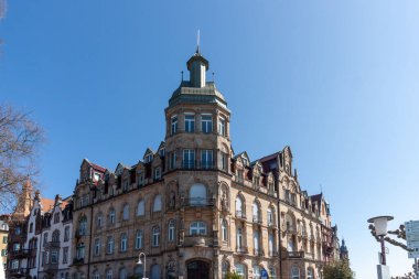 KONSTANZ, GERMANY - 5 Nisan 2025: Karmaşık mimari detaylarla süslü tarihi bir bina ve yeşil kubbeli kendine özgü bir köşe kulesi Konstanz 'da açık mavi bir gökyüzüne karşı duruyor (Constance, Almanya)