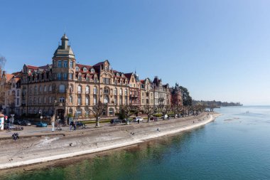 Almanya 'nın Konstanz kentinde, Constance Gölü' nün (Bodensee) sakin kıyıları boyunca uzanan tarihi rıhtım sahasının geniş, pitoresk bir manzarası.)