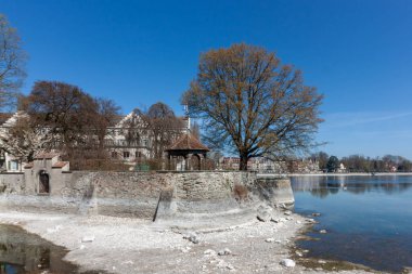 Constance Gölü (Bodensee) kıyıları boyunca sakin bir manzara, su seviyesinin düşük olması nedeniyle göl yatağının bir kısmını açığa çıkaran, su hattı boyunca kıvrımlı tarihi bir taş ihtiva etmektedir.