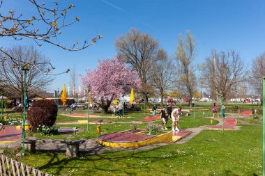 KREUZLINGEN, SWitzERLAND - 5 Nisan 2025: İnsanlar İsviçre Kreuzlingen 'de canlı bir sahada rahatlatıcı bir minigolf oyununun keyfini çıkarıyorlar