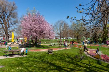 KREUZLINGEN, SWitzERLAND - 5 Nisan 2025: İnsanlar İsviçre Kreuzlingen 'de canlı bir sahada rahatlatıcı bir minigolf oyununun keyfini çıkarıyorlar