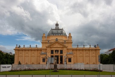 ZAGREB, CROATIA - 22 Mayıs 2025: Hırvatistan 'ın Zagreb kentindeki görkemli Sanat Pavyonu bulutlu bir gökyüzünün altında görkemli bir şekilde duruyor
