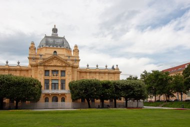 ZAGREB, CROATIA - 22 Mayıs 2025: Hırvatistan 'ın Zagreb kentindeki görkemli Sanat Pavyonu bulutlu bir gökyüzünün altında görkemli bir şekilde duruyor